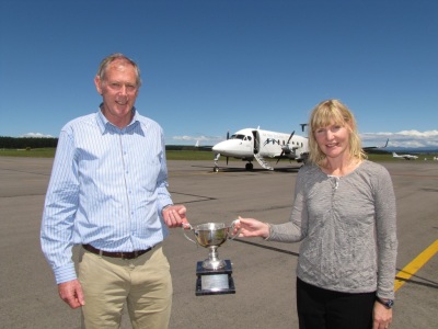 Taup&#333; Airport Manager Mike Groome and Operations Manager Kim Gard holding the 'Regional Airport Award' trophy with an Air New Zealand Beech 1900 D aircraft in the background.